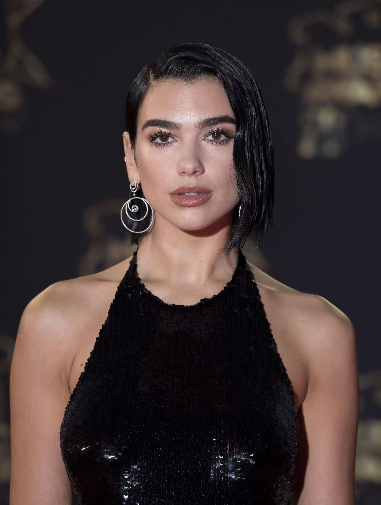 Dua Lipa wet look black asymmetrical bob hairstyle