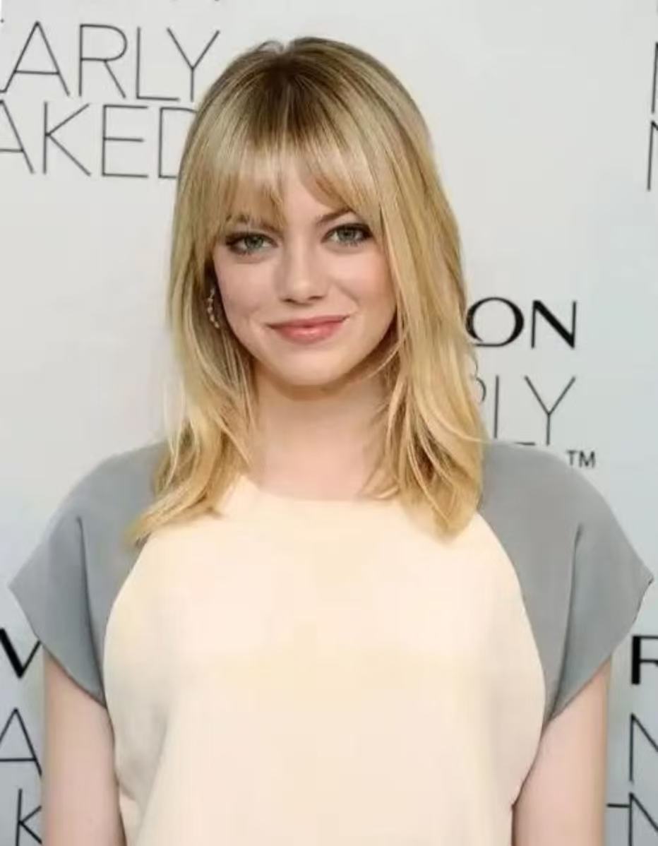 Emma Stone shaggy blonde layered hairstyle with bangs