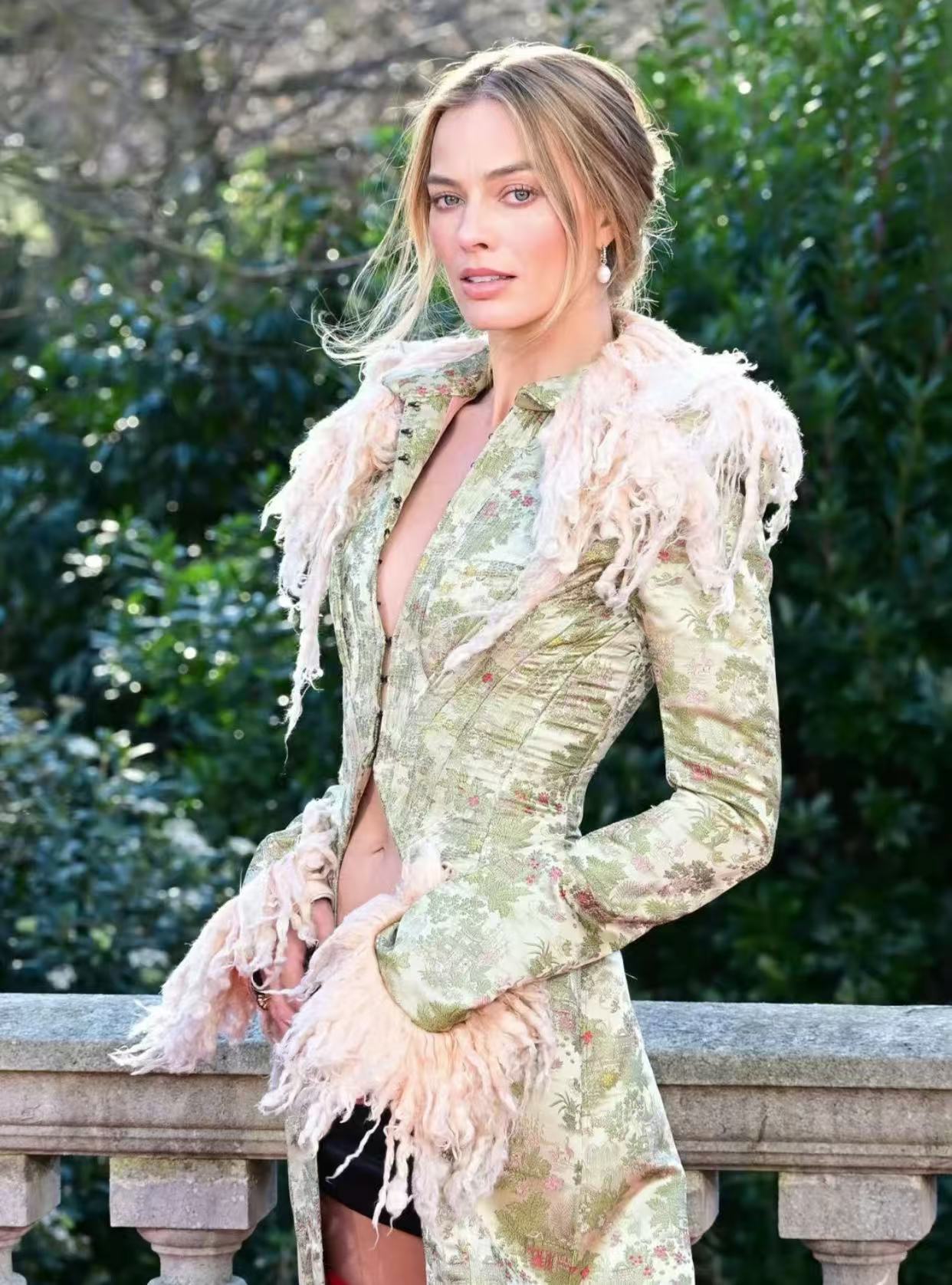 Margot Robbie romantic blonde updo with loose tendrils