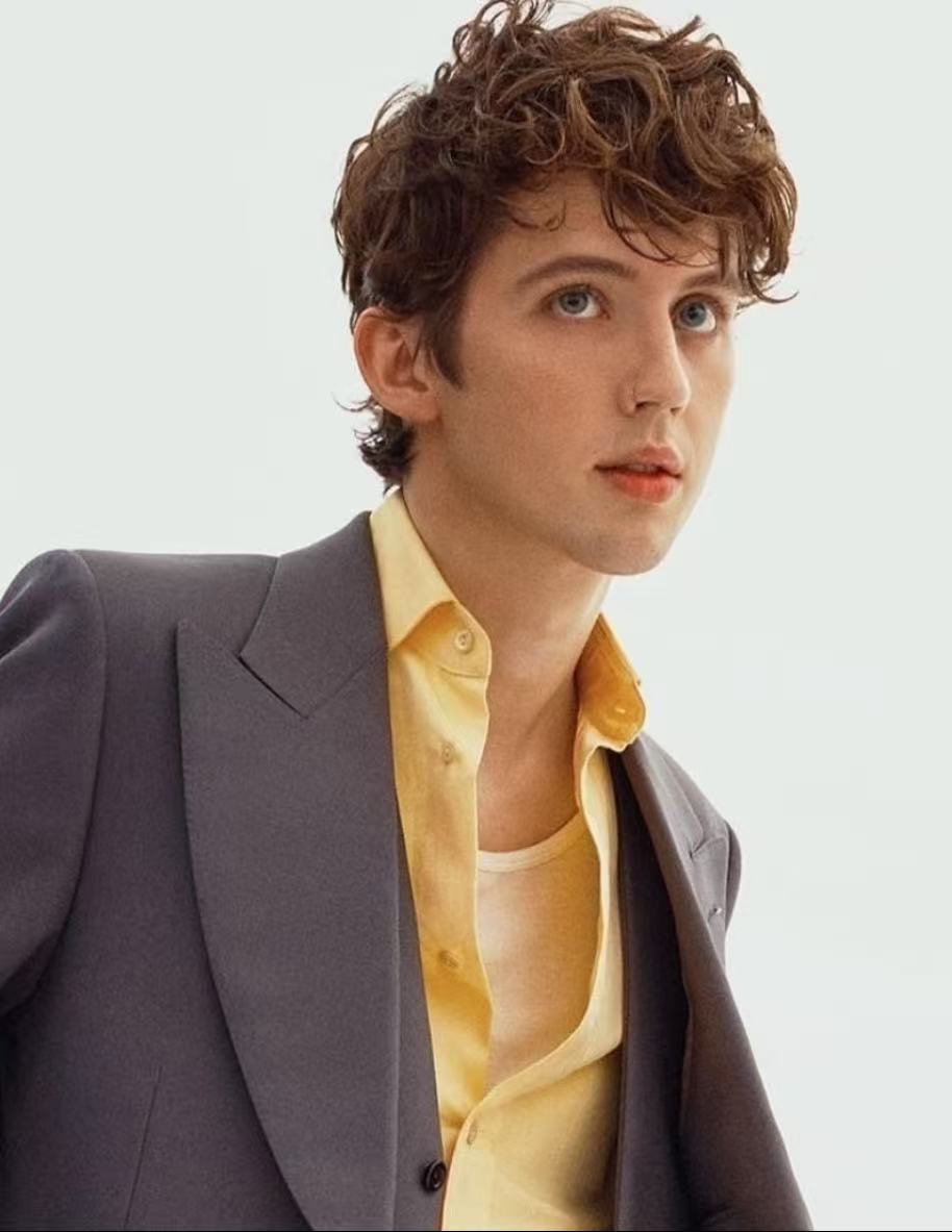 Troye Sivan soft brunette curly hairstyle with yellow shirt